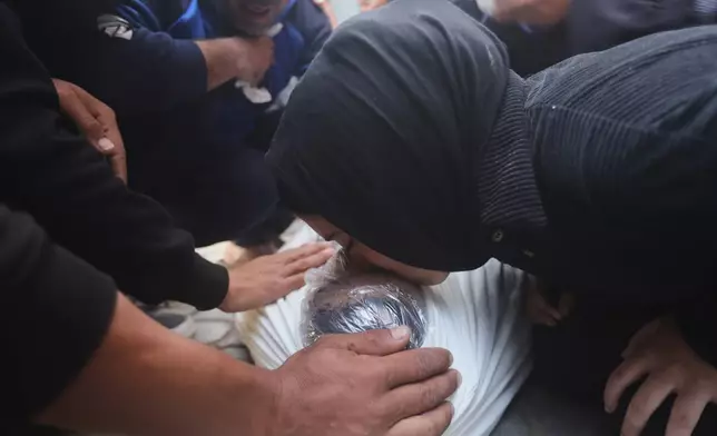 Palestinians mourn over Al-Tanani family members killed in an Israeli strike, during their funeral at Al-Shifa Hospital in Gaza City, Saturday, April 25, 2026. (AP Photo/Yousef Alzanoun)