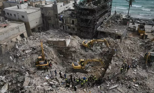 Excavators remove rubble from buildings destroyed in Israeli airstrikes on Thursday as rescuers search for victims in the city of Tyre, southern Lebanon, Saturday, April 18, 2026. (AP Photo/Bilal Hussein)