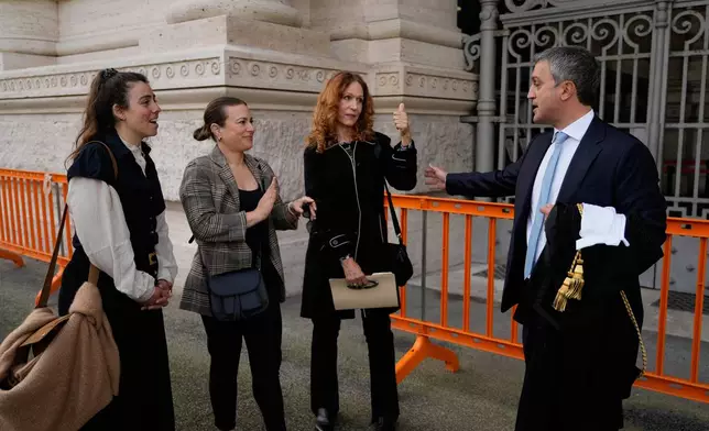 Italian Lawyer Marco Mellone, right, greets Alexis Traino, left, Jacqueline Romano and Karen Bonadio from United States, outside Italy's highest Court of Cassation, in Rome, Tuesday, April 14, 2026, prior to the start of a hearing to argue against the new citizenship law that restricts citizenship by descent. (AP Photo/Gregorio Borgia)