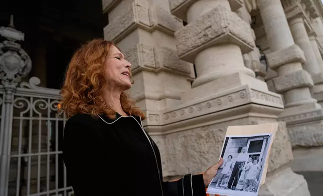 Karen Bonadio, from the United States, holds a picture of her and her grandfather Giuseppe Nicola Montesano, as she is interviewed by the Associated Press outside Italy's highest Court of Cassation, in Rome, Tuesday, April 14, 2026, prior to the start of a hearing to argue against the new citizenship law that restricts citizenship by descent. (AP Photo/Gregorio Borgia)