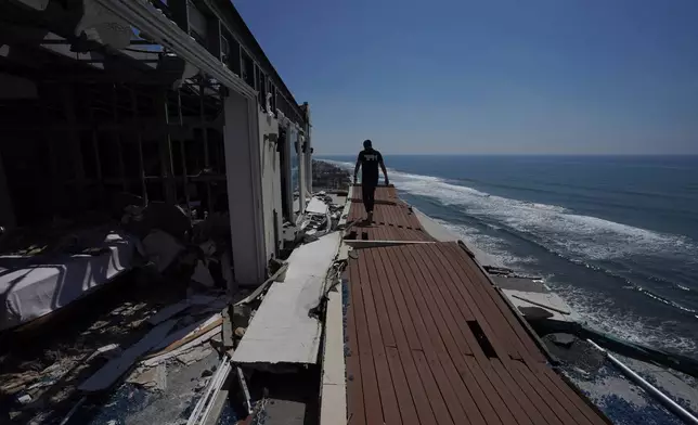 FILE - A man walks alongside damaged apartments in the aftermath of Hurricane Otis, in the Diamonds subdivision of Acapulco, Mexico, Nov. 9, 2023. (AP Photo/Marco Ugarte, File)