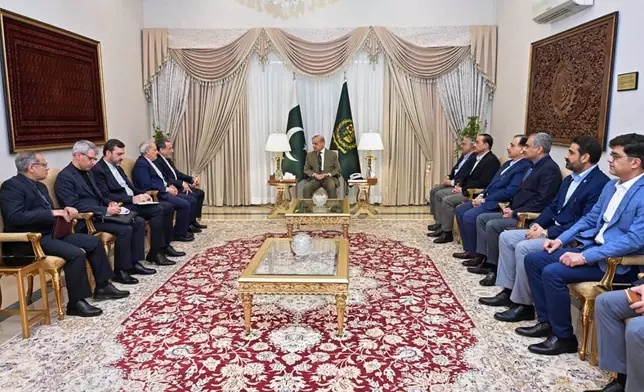 In this photo released by the Pakistan Prime Minister Office, Iran's Foreign Minister Abbas Araghchi, fifth left, meets with Prime Minister Shehbaz Sharif, center, in Islamabad, Pakistan, Saturday, April 25, 2026. (Pakistan Prime Minister Office via AP)