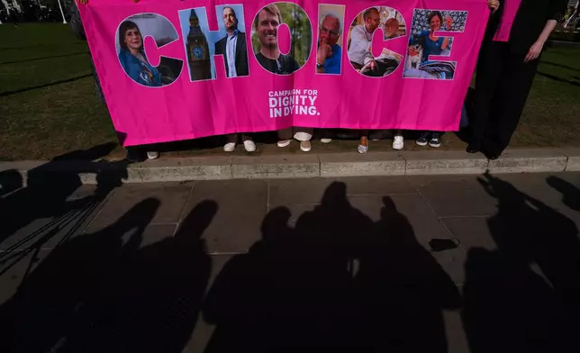 Campaigners hold a banner outside parliament in London as a proposed law to legalise assisted dying in England and Wales will run out of time on Friday, more than a year after MPs first voted in favour of it, Friday, April 24, 2026. (AP Photo/Kirsty Wigglesworth)