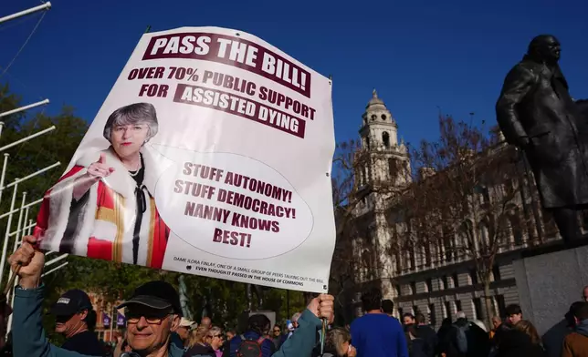 A campaigner holds a banner outside parliament in London as a proposed law to legalise assisted dying in England and Wales will run out of time on Friday, more than a year after MPs first voted in favour of it, Friday, April 24, 2026. (AP Photo/Kirsty Wigglesworth)
