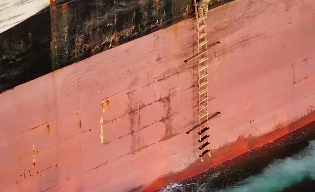 In this photo released by Tasnim News Agency, Revolutionary Guard Navy (IRGC) armed men climb aboard the cargo ship MSC Francesca during what state media described as the seizure of one of two vessels accused of violations in the Strait of Hormuz, April 21, 2026. (Meysam Mirzadeh/Tasnim News Agency via AP)