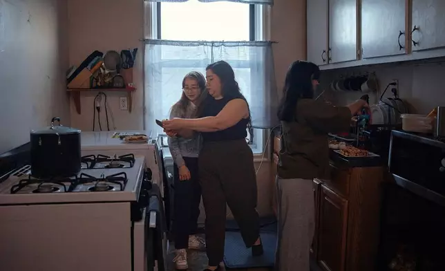 Gulhayo Yuldosheva helps get her children ready for school in an apartment building where tenants report maintenance issues and pest infestations, in the Bronx borough of New York, Tuesday, March 17, 2026. (AP Photo/Andres Kudacki)