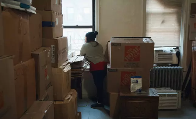 Marina Quiroz looks through the window in an apartment building where tenants report maintenance issues and pest infestations, in the Bronx borough of New York, Tuesday, March 17, 2026. (AP Photo/Andres Kudacki)