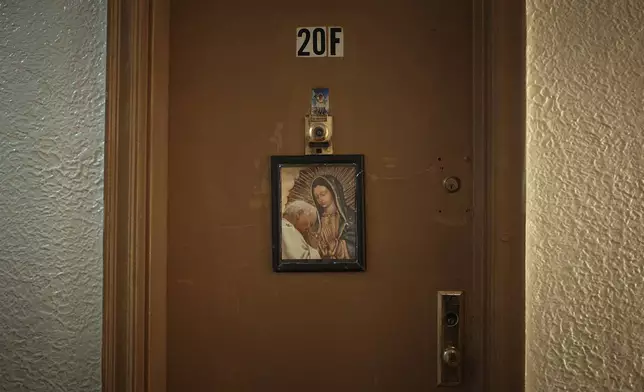 A religious image hangs from a front door in an apartment building where tenants report maintenance issues and pest infestations, in the Bronx borough of New York, Tuesday, March 17, 2026. (AP Photo/Andres Kudacki)