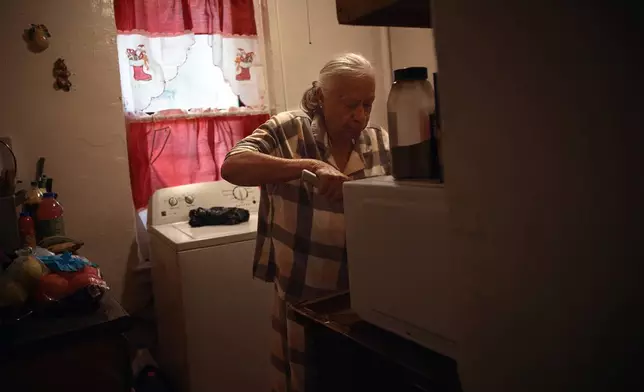 Maria Rodriguez prepares food in an apartment building where tenants report maintenance issues and pest infestations, in the Bronx borough of New York, Tuesday, March 17, 2026. (AP Photo/Andres Kudacki)
