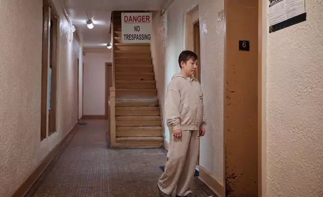 Gulhayo Yuldosheva's son, Heriberto, 11, stands in an apartment building where tenants report maintenance issues and pest infestations, in the Bronx borough of New York, Tuesday, March 17, 2026. (AP Photo/Andres Kudacki)