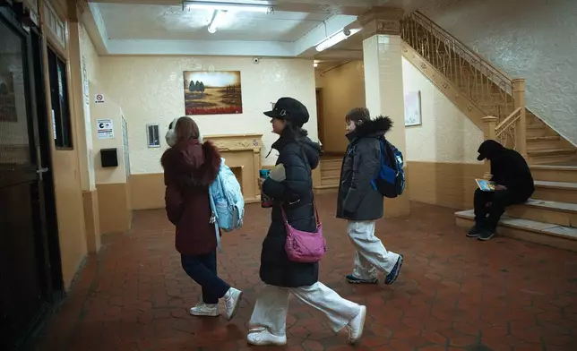 Gulhayo Yuldosheva's kids leave for school in an apartment building where tenants report maintenance issues and pest infestations, in the Bronx borough of New York, Tuesday, March 17, 2026. (AP Photo/Andres Kudacki)