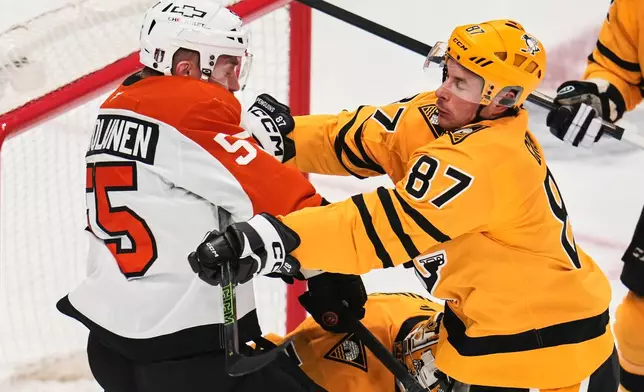 Pittsburgh Penguins' Sidney Crosby (87) checks Philadelphia Flyers' Rasmus Ristolainen (55) in front of Penguins goalie Stuart Skinner, center bottom, during the first period of Game 2 in the first round of the NHL Stanley Cup playoffs in Pittsburgh, Monday, April 20, 2026. (AP Photo/Gene J. Puskar)