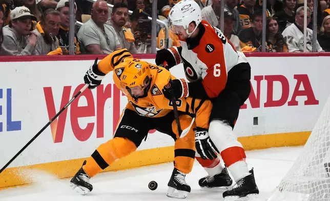 Pittsburgh Penguins' Sidney Crosby (87) is defended by Philadelphia Flyers' Travis Sanheim (6) during the second period of Game 1 in the first round of the NHL Stanley Cup playoffs in Pittsburgh, Saturday, April 18, 2026. (AP Photo/Gene J. Puskar)