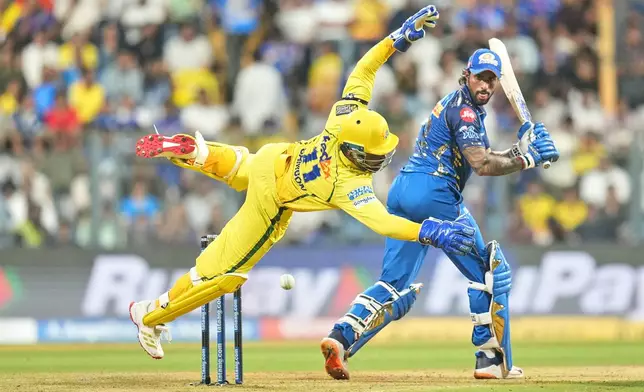 Chennai Super Kings' Sanju Samson dives to field the ball as Mumbai Indians' Tilak Varma looks back after playing a shot during the Indian Premier League cricket match between Mumbai Indians and Chennai Super Kings in Mumbai, India, Thursday, April 23, 2026.(AP Photo/ Rafiq Maqbool)