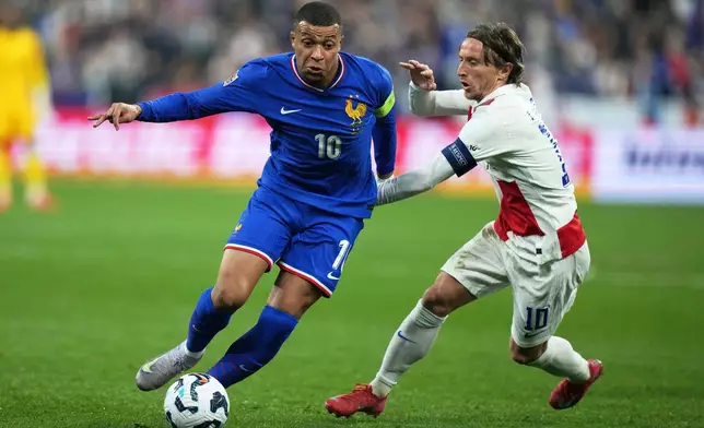 FILE - France's Kylian Mbappe, left, is challenged by Croatia's Luka Modric during the UEFA Nations League quarterfinal second leg soccer match between France and Croatia, at the Stade de France in Saint-Denis, outside Paris, Sunday, March 23, 2025. (AP Photo/Thibault Camus, File)