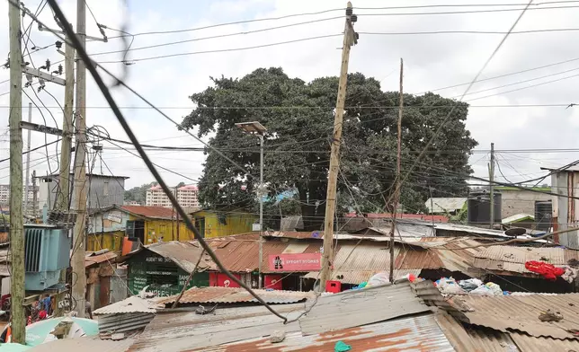 A view of electric wire poles and cables towering over the Kibera informal settlement in Nairobi, Kenya, Tuesday, March 31, 2026. (AP Photo/Henry Naminde)