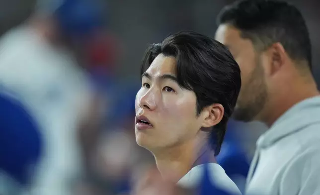 Los Angeles Dodgers' Hyeseong Kim watches from the dugout during the third inning of a baseball game against the New York Mets Wednesday, April 15, 2026, in Los Angeles. (AP Photo/Jae C. Hong)