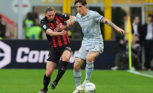 AC Milan's Adrien Rabiot, left, and Udinese's Nicolo Zaniolo fight for the ball during the Serie A soccer match between AC Milan and Udinese, in Milan, Italy, Saturday, April 11, 2026. (AP Photo/Antonio Calanni)
