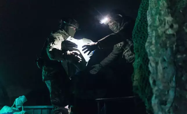 Soldiers from Ukraine's Khartia brigade load ammunition onto a combat ground drone bound for the front line in Kharkiv region, Ukraine, Jan. 27, 2026. (AP Photo/Nikoletta Stoyanova)