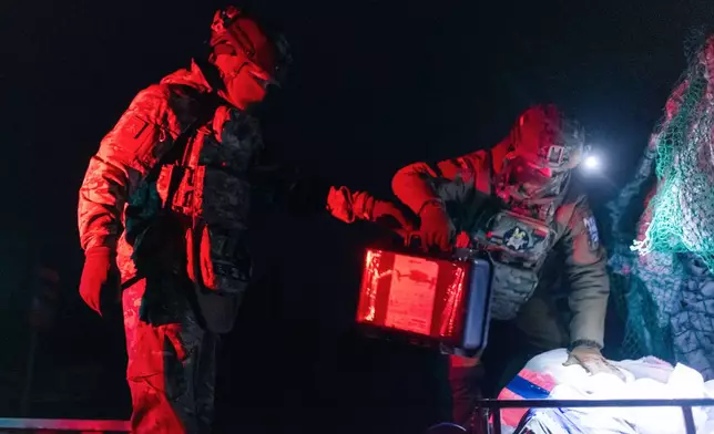 Soldiers from Ukraine's Armed Forces Khartia brigade load ammunition on a combat ground drone bound for the front line in Kharkiv region, Ukraine, Jan. 27, 2026. (AP Photo/Nikoletta Stoyanova)
