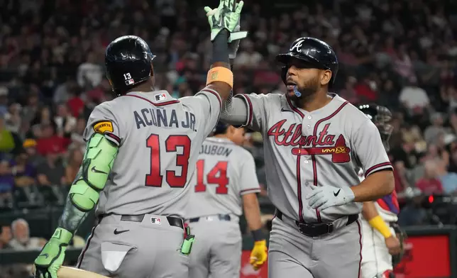 Atlanta Braves' Dominic Smith celebrates with Ronald Acuña Jr. (13) after hitting a solo home run against the Arizona Diamondbacks in the third inning of a baseball game, Thursday, April 2, 2026, in Phoenix. (AP Photo/Rick Scuteri)