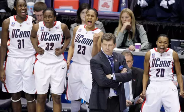 FILE - Connecticut's Tina Charles (31), Kalana Greene (32), Maya Moore (23) and Renee Montgomery (20) celebrate behind coach Geno Auriemma in the final moments of Connecticut's 83-64 win over Stanford in a semifinal of the NCAA women's college basketball tournament Final Four on Sunday, April 5, 2009, in St. Louis.. (AP Photo/Jeff Roberson, File)