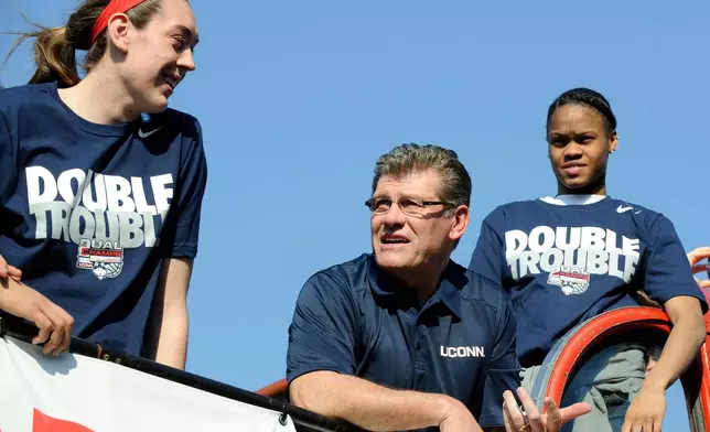 FILE - Connecticut coach Geno Auriemma, center, watches the crowd with Breanna Stewart, left, and Moriah Jefferson during a parade in Hartford, Conn., on Sunday, April 13, 2014, celebrating their recent NCAA national championship. (AP Photo/Fred Beckham)