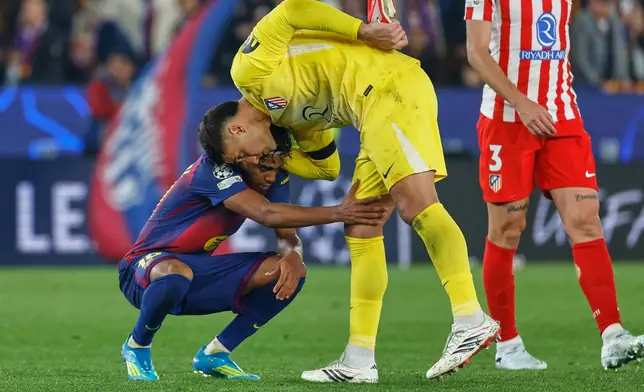 Atletico Madrid's goalkeeper Juan Musso comforts Barcelona's Lamine Yamal after the Champions League quarterfinal first leg soccer match between Barcelona and Atletico Madrid in Barcelona, Spain, Wednesday, April 8, 2026. (AP Photo/Joan Monfort)