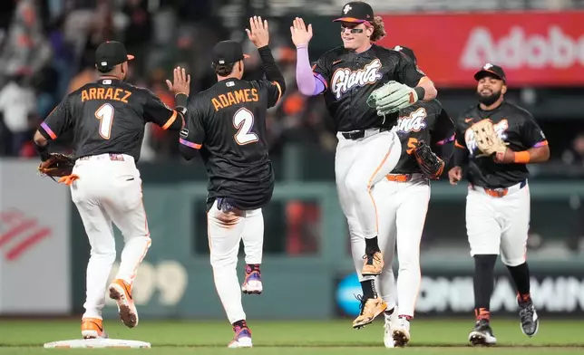 San Francisco Giants' Luis Arraez, from left, celebrates with Willy Adames (2), Harrison Bader, Jung Hoo Lee and Heliot Ramos after a baseball game against the Philadelphia Phillies in San Francisco, Tuesday, April 7, 2026. (AP Photo/Jeff Chiu)