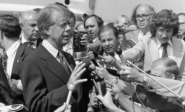 FILE - Democratic presidential nominee Jimmy Carter speaks to reporters on his arrival at Hobby International Airport in Houston Sept. 24, 1976. (AP Photo/Jack Thornell, File)