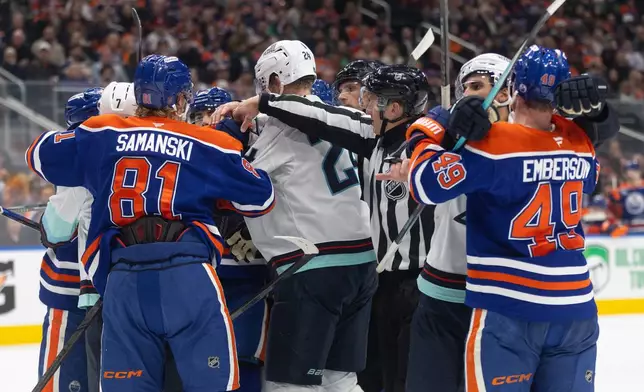 Seattle Kraken and the Edmonton Oilers players rough it up during third period NHL action, in Edmonton on Tuesday March 31, 2026. (Jason Franson/The Canadian Press via AP)