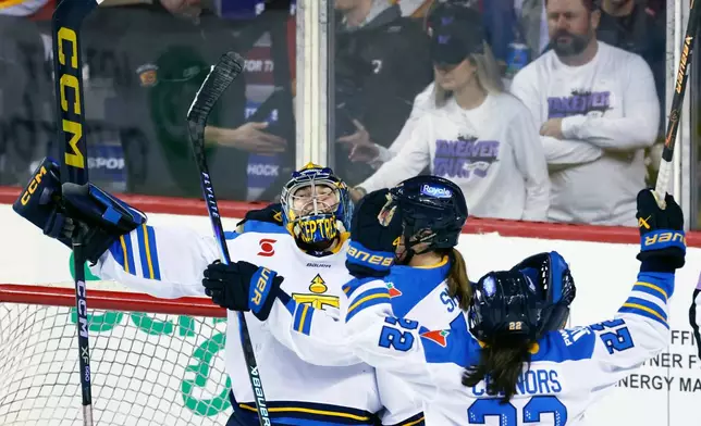 Toronto Sceptres goalie Raygan Kirk, left, celebrates with teammates after defeating the Ottawa Charge in a PWHL hockey game in Calgary, Alberta, Wednesday, April 1, 2026. (Larry MacDougal/The Canadian Press via AP)