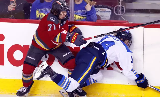 Toronto Sceptres' Renata Fast, right, is knocked down by Ottawa Charge's Fanuza Kadirova during first period PWHL Takeover Tour hockey game in Calgary, on Wednesday, April 1, 2026. (Larry MacDougal/The Canadian Press via AP)