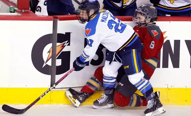 Toronto Sceptres' Emma Maltais, left, knocks down Ottawa Charge's Kathryn Reilly during second period PWHL Takeover Tour hockey action in Calgary, Wednesday, April 1, 2026. (Larry MacDougal/The Canadian Press via AP)