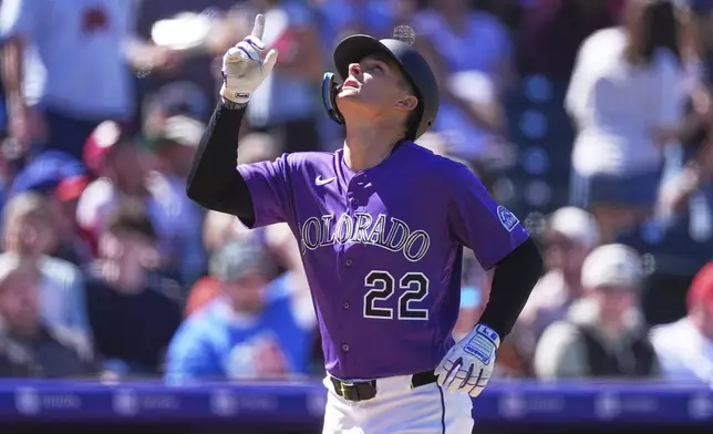 Colorado Rockies' Mickey Moniak gestures as he circles the bases after hitting a solo home run off Philadelphia Phillies starting pitcher Taijuan Walker in the fifth inning of a baseball game Sunday, April 5, 2026, in Denver. (AP Photo/David Zalubowski)
