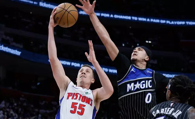 Detroit Pistons forward Duncan Robinson (55) goes to the basket past Orlando Magic guard Anthony Black (0) during the first half in Game 1 of a first-round NBA basketball playoffs series Sunday, April 19, 2026, in Detroit. (AP Photo/Duane Burleson)