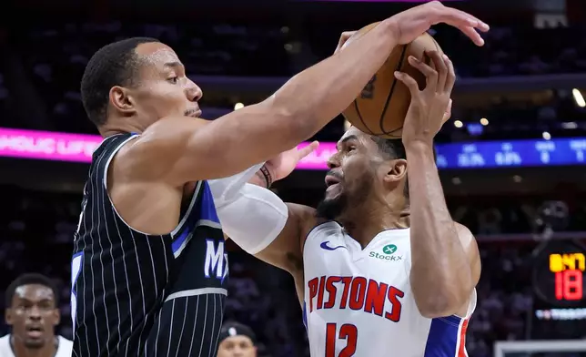Detroit Pistons forward Tobias Harris (12) is defended by Orlando Magic guard Desmond Bane, front left, during the first half in Game 1 of a first-round NBA basketball playoffs series Sunday, April 19, 2026, in Detroit. (AP Photo/Duane Burleson)