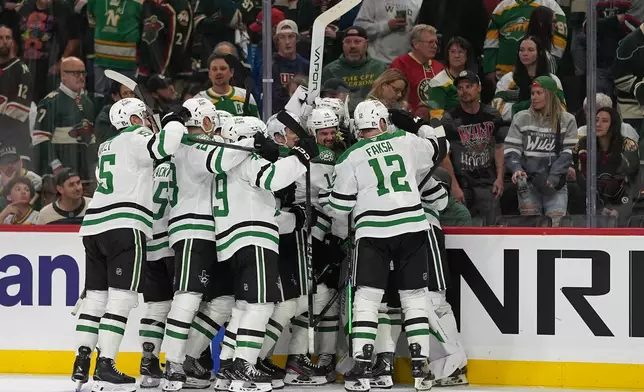 Dallas Stars players celebrate after the double overtime win against the Minnesota Wild of Game 3 in the first round of the NHL Stanley Cup hockey playoffs early morning Thursday, April 23, 2026, in St. Paul, Minn. (AP Photo/Abbie Parr)