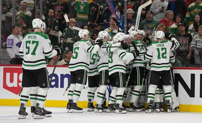 Dallas Stars players celebrate after the double overtime win against the Minnesota Wild of Game 3 in the first round of the NHL Stanley Cup hockey playoffs early morning Thursday, April 23, 2026, in St. Paul, Minn. (AP Photo/Abbie Parr)