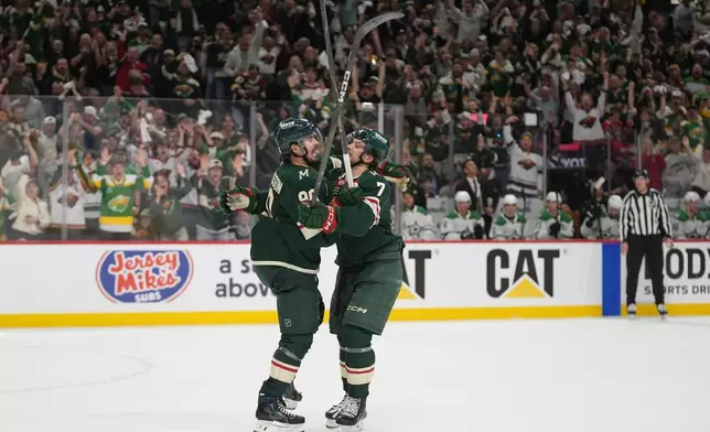 Minnesota Wild left wing Marcus Johansson (90), left, celebrates with defenseman Brock Faber (7) after scoring a goal during the first period of Game 3 in the first-round of the NHL Stanley Cup hockey playoffs against the Dallas Stars Wednesday, April 22, 2026, in St. Paul, Minn. (AP Photo/Abbie Parr)