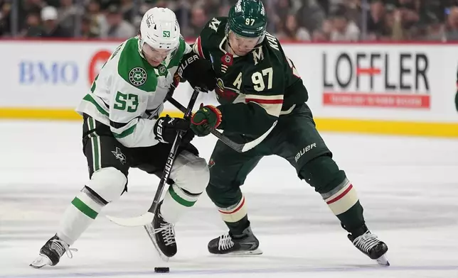 Dallas Stars center Wyatt Johnston (53) and Minnesota Wild left wing Kirill Kaprizov (97) battle for the puck during the second period of Game 3 in the first round of the NHL Stanley Cup hockey playoffs Wednesday, April 22, 2026, in St. Paul, Minn. (AP Photo/Abbie Parr)
