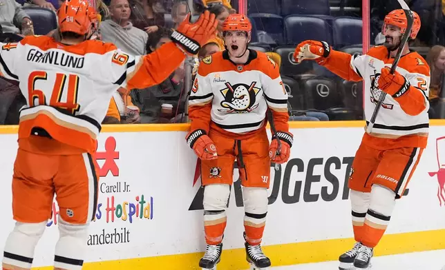 Anaheim Ducks right wing Troy Terry (19) celebrates his goal with center Mikael Granlund (64) and left wing Chris Kreider, right, during the third period of an NHL hockey game Thursday, April 16, 2026, in Nashville, Tenn. (AP Photo/George Walker IV)