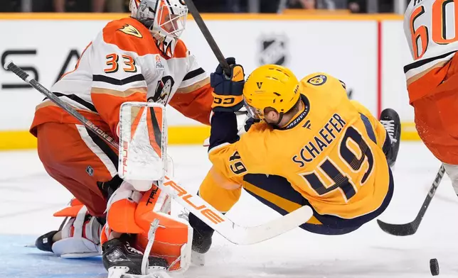 Nashville Predators left wing Reid Schaefer (49) collides with Anaheim Ducks goaltender Ville Husso (33) during the second period of an NHL hockey game Thursday, April 16, 2026, in Nashville, Tenn. (AP Photo/George Walker IV)