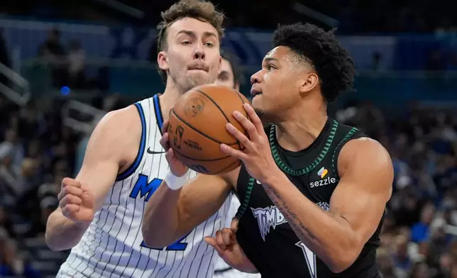 Minnesota Timberwolves guard Terrence Shannon Jr., right, goes to the basket against Orlando Magic forward Franz Wagner, left, during the first half of an NBA basketball game, Wednesday, April 8, 2026, in Orlando, Fla. (AP Photo/John Raoux)
