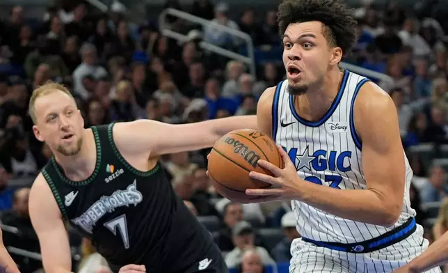 Orlando Magic forward Noah Penda, right, drives past Minnesota Timberwolves forward Joe Ingles (7) during the second half of an NBA basketball game, Wednesday, April 8, 2026, in Orlando, Fla. (AP Photo/John Raoux)