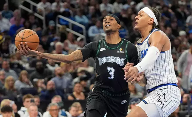 Minnesota Timberwolves forward Jaden McDaniels (3) goes up for a shot against Orlando Magic forward Paolo Banchero during the first half of an NBA basketball game, Wednesday, April 8, 2026, in Orlando, Fla. (AP Photo/John Raoux)