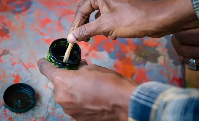Dahir Yousef Abdi, guide from the Somali Region Pastoral and Agro-pastoral Research Institute, demonstrates ink made from myrrh Friday Jan. 9, 2026, in Sanqotor, Ethiopia. Myrrh, in Islam tradition, is turned into a black ink used only for writing the Quran and symbolizes the connection between the word and the divine. (AP Photo/Julianne Gauron)