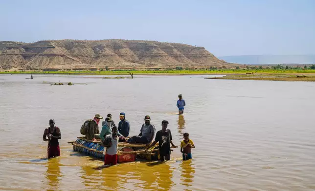 Myrrh researchers cross the Shebelle River with the help of boatmen that wade in the low levels instead of paddling as they make their way toward East Imi, Ethiopia, Saturday Jan. 10, 2026. (AP Photo/Julianne Gauron)