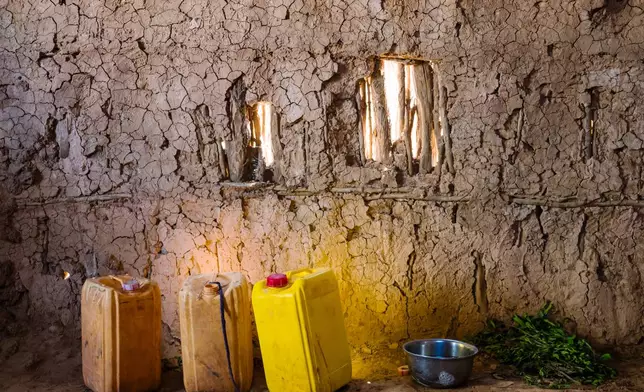 Yellow jerrycans, for hauling water, sit next to a bowl for washing up and a pile of khat leaves Friday Jan. 9, 2026, in Sanqotor, Ethiopia. (AP Photo/Julianne Gauron)