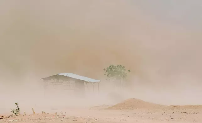 Dust engulfs a home and tree barely visible made worse amid a drought on Friday Jan. 9, 2026, in Sanqotor, Ethiopia. (AP Photo/Julianne Gauron)